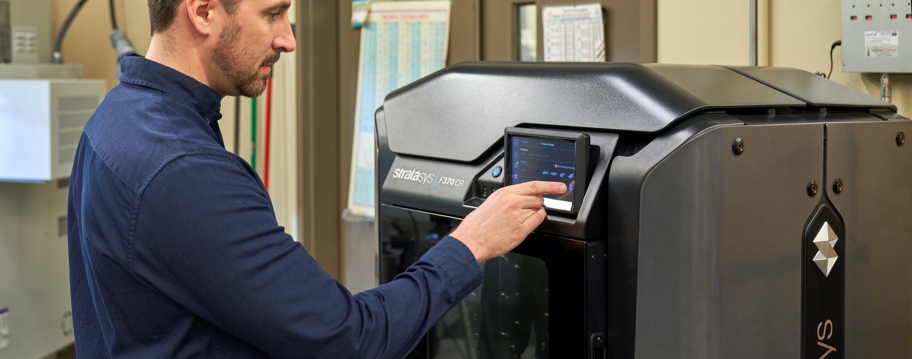 Engineer standing next to a Stratasys printer.